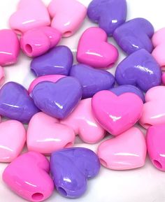 pink and purple heart shaped beads on a white surface