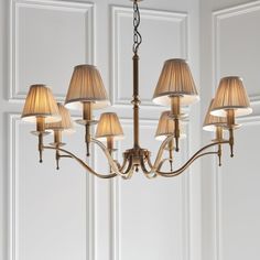 a chandelier with six lamps hanging from it's sides in a room