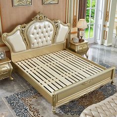 a gold colored bed with white and beige furniture in a room that has carpeted flooring