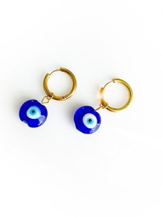 The creme de la creme evil eye huggie hoop earrings. Stylish, timeless and crafted authentically. Glass Evil Eye Beads off a stainless steel secure hoop earring! Dress up or keep it casual, these are an essential in your evil eye collection case. Comes in custom FRESHALAMODE packaging and evil eye description card!  *ready to gift. Eye Description, Evil Eye Blue, Glass Evil Eye, Evil Eye Beads, Beaded Earrings Tutorials, Evil Eye Ring, Earring Tutorial, Eye Beads, Pretty Packaging