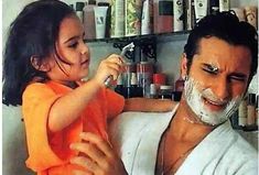 the man is shaving his daughter's face