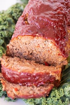 sliced meatloaf with sauce on top of it and kale sprouts