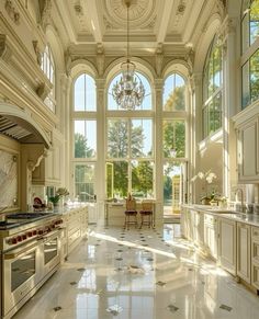 a large kitchen with white cabinets and marble flooring is pictured in this image, there are two chandeliers hanging from the ceiling