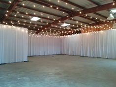 an empty room with white curtains and lights