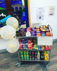 a display case with balloons and snacks on it