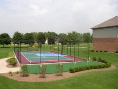 a tennis court surrounded by lush green grass