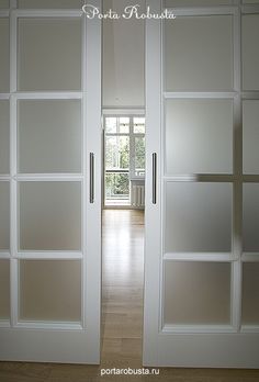 an empty room with white doors and windows