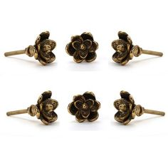 four pieces of gold colored metal with flowers on each side and one flower in the middle