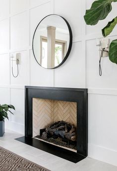 a fireplace with a mirror above it and a plant on the wall next to it