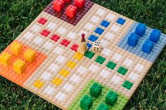 a board game made out of legos on the grass with dices and blocks