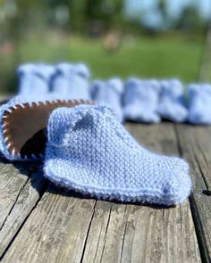 a pair of blue knitted slippers sitting on top of a wooden table next to each other