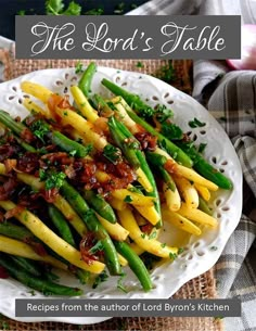 a white plate topped with green beans and other food items on top of a table