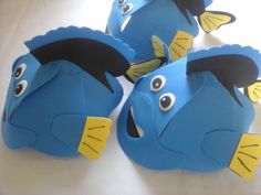 three blue fish with yellow eyes and black ears on them, sitting next to each other