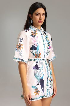 a woman wearing a white floral print dress