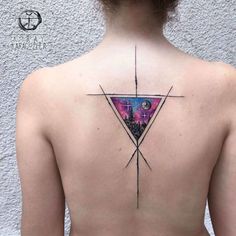 the back of a woman's neck with a triangle tattoo on her left shoulder