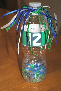 a water bottle decorated with blue, green and white confetti is sitting on a table