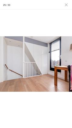 an empty room with wooden floors and white walls