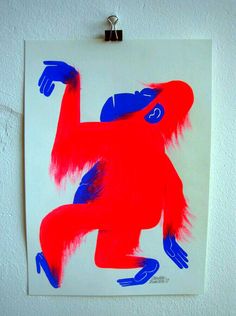 a drawing of a red and blue monkey on a white wall with clippings