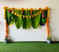 there is a green wall decorated with flowers and garlands