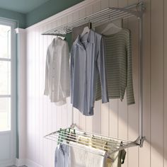 clothes are hanging on the rail in front of an open window, while another shirt is hung next to it