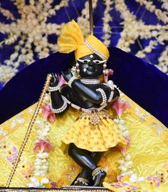 a statue of a person dressed in black and yellow sitting on top of a table