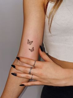 a woman's arm with a butterfly tattoo on the left side of her arm