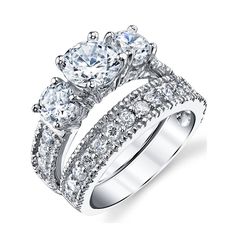 three stone engagement ring set with round diamonds on the sides and side stones in white gold