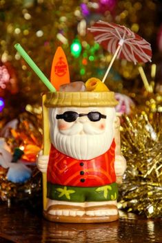 a santa clause figurine with an umbrella and hat on top of a table