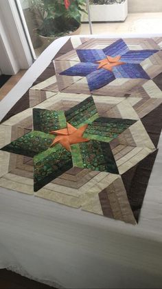 a quilted table topper sitting on top of a bed