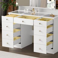 a white vanity with gold drawers and mirror