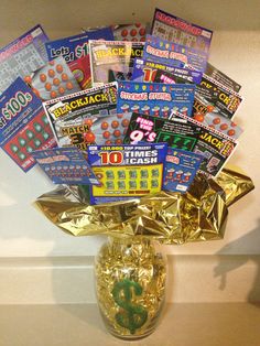 a gold vase filled with lots of magazine's and candy bar wrapper wrapped around it