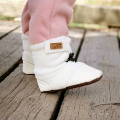 Our Stay-Put Cozy Booties are guaranteed to stay on the most active little kickers!    Stay-Put Design: Adjustable elastic drawstring around ankle and easy Velcro tab  Cozy: Made with soft and warm fleece  Flexible Soles: Durable PU soles, reinforced at toe and heel  Lightweight: Perfect for babies and first-time walkers  Easy Care: Machine washable on gentle cycle, air dry   Back to Stay Put Baby Booties | See all Infant Footwear Casual Winter Booties With Plush Lining, Comfortable Soft Booties For Playtime, Comfortable White Winter Boots, Casual Warm Booties For Winter, Casual Warm Winter Booties, Winter Playtime Booties With Soft Sole, Comfortable Winter Booties With Plush Lining, Non-slip White Winter Boots, White Non-slip Winter Boots