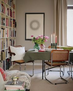 a dining room table with flowers in a vase on it