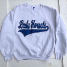 90s Lady Hornets Sweater, Fitted White Pullover Sweatshirt, 90s Cheer Sweatshirt, 90s Cheerleader Sweatshirt, Vintage Lady Hornets Size Medium Made in El Salvador Russell Athletic 50% Cotton 50% Polyester Measurements: Shoulders- 21 inches Chest- 43 inches Sleeve length- 22 inches Length- 24.5 inches B6 90s Crew Neck Tops For Game Day, 90s Style Sweatshirt For Game Day, 90s Long Sleeve Top For Game Day, 90s Style Long Sleeve Tops For Game Day, White Throwback College Sweatshirt, 90s Cheerleader, Athletic Sweater, White Pullover, Vintage Lady