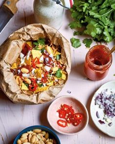 several different types of food sitting on a table next to bowls and utensils