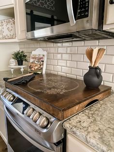 a stove top oven sitting inside of a kitchen next to a microwave above a counter