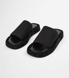 We're know you love effortless style. Cue our Isabel slides in classic black. Featuring an elevated platform foot bed, with simple fabric strap design, they're the perfect Summer sandal for the minimalist. - Material: Fabric upper and rubber lining - Toe-shape: Round toe shape - Pattern: Fabric strap - Fit: Runs true to size - Heel Height: 1.5cm Modern Black Platform Slippers With Rubber Sole, Modern Black Platform Slippers With Textured Sole, Modern Black Leather Platform Slippers, Black Platform Slip-on Slides, Black Platform Slippers With Textured Sole For Spring, Comfortable Black Leather Platform Slippers, Black Platform Slide Mules, Black Open Toe Platform Slippers With Rubber Sole, Black Leather Platform Slides