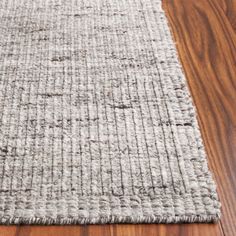 a close up of a wooden floor with a rug on top of it and wood floors in the background