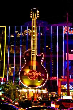 an electric guitar is lit up in front of the hard rock hotel and casino at night