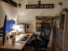 a computer desk with a monitor, keyboard and mouse on it in a small room