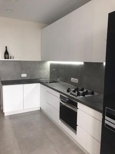 an empty kitchen with white cabinets and black counter tops is seen in this image from the front view