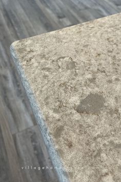 a close up view of the top of a table with wood flooring in the background