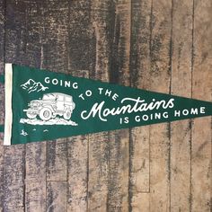 a green pennant with the words going to the mountains is going home written on it