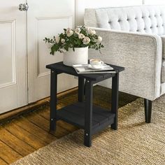 a living room with a couch, coffee table and flower pot on the end table