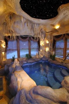 an indoor swimming pool in the middle of a room with large windows and icicles hanging from the ceiling