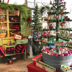 a room filled with lots of christmas trees and ornaments in buckets on the floor