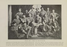 an old black and white photo of men in uniforms posing for a group photograph with hats on