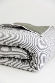 the folded bedding is made up of black and white striped sheets