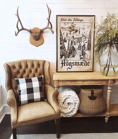 a chair and table in a room with antlers on the wall behind it,