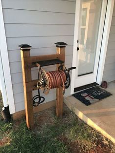 a horse's head is mounted to the side of a wooden stand on grass next to a door